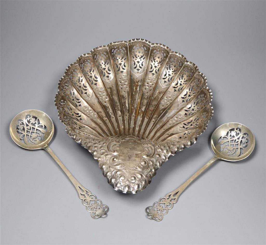 An Edwardian silver embossed and pierced scallop shaped dish, 28.3cm, Sheffield, 1905 and a pair of pierced silver spoons,12.5oz.